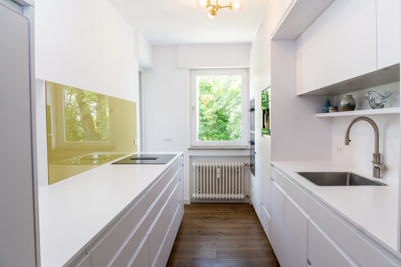 Immobilienfotograf Stuttgart, moderne weiße Küche mit Holzboden professionell fotografiert